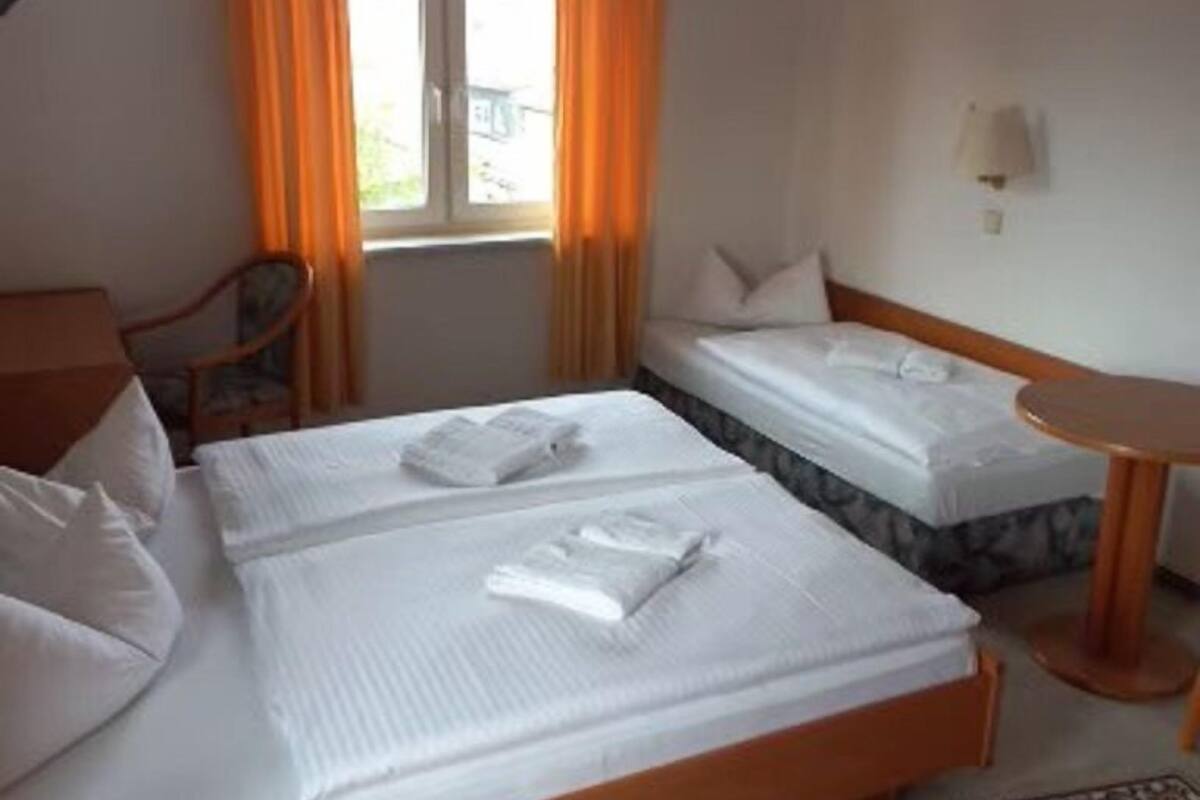 Habitación de hotel con dos camas, un escritorio y una silla.