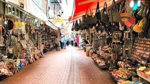 A narrow market street with various stalls selling bags and other goods. - Yildiz Pansiyon (Amasra)