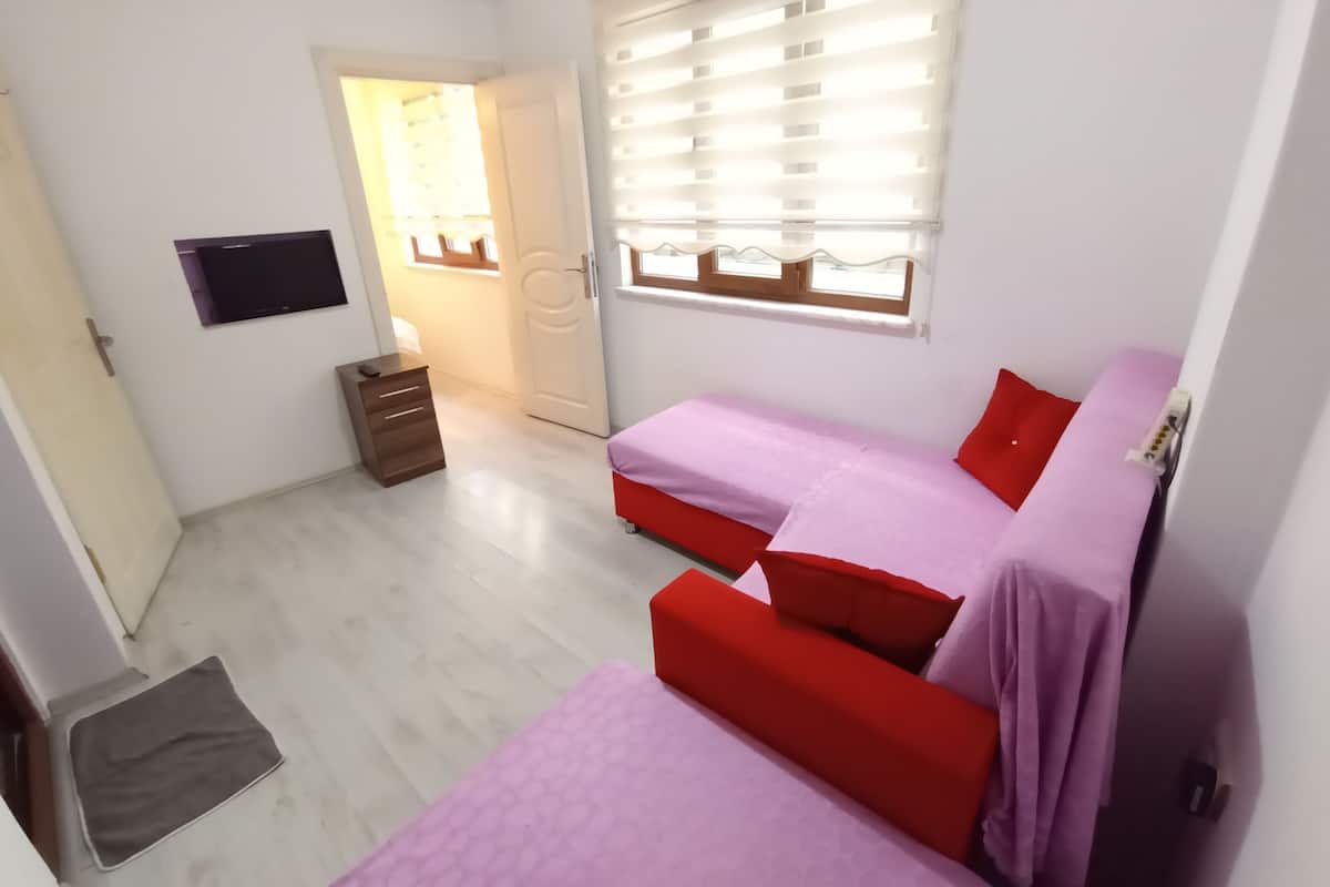 Habitación familiar, 1 habitación, vista a la ciudad | Área de sala de estar | Televisión LED
