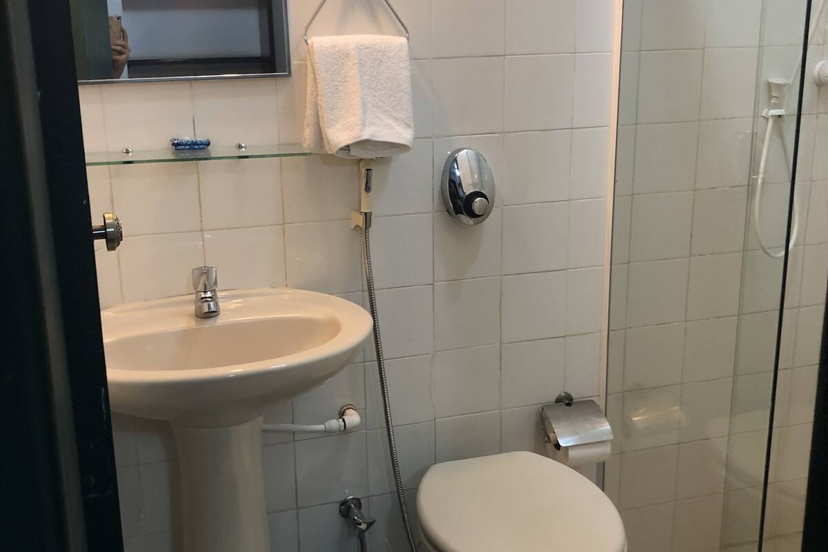 A bathroom with a sink, toilet, and glass shower enclosure.