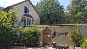 A building with a balcony, a door labeled "KRAZY KAT", and outdoor seating. - The Inn at Montchanin Village, a Historic Hotel of America (Wilmington)