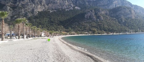 In Strandnähe, weißer Sandstrand, Liegestühle, Sonnenschirme