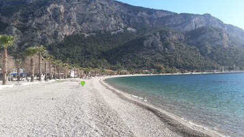 Perto da praia, areia branca, espreguiçadeiras, guarda-sóis 