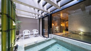 Área de spa com hidromassagem, assentos e uma parede de vidro que oferece vista do interior.