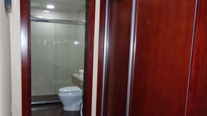Pasillo que lleva a un baño con inodoro y zona de ducha.