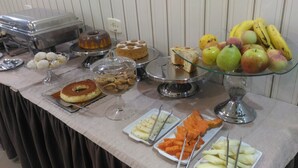 En buffet med forskellige spisemuligheder, blandt andet kager, frugt og grøntsager.