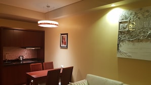A cozy living room with a dining area, a kitchen with wooden cabinets, and a wall-mounted map. - Apartment on Batumskaya 16-9 ap. 22 (Batumi)