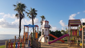 A beach playground with climbing structures, slides, and a tower. - Apartment on Batumskaya 16-9 ap. 22 (Batumi)