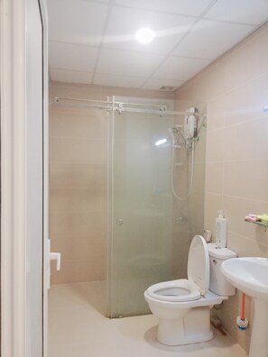A bathroom with a glass-enclosed shower, a toilet, and a sink. - Apartment Sea View (Ho Chi Minh City)
