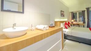 A hotel bathroom with a large sink, mirror, and towel rack. - OYO Flagship 1260 Sentraland Karawang (Karawang)