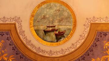 A circular window with a maritime scene.