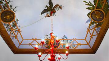 A chandelier with multiple light fixtures and a bird design on the ceiling.