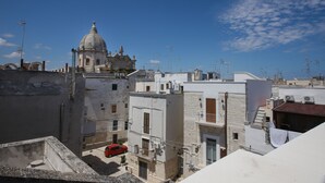 Vista de un edificio histórico con una cúpula, rodeado de edificios modernos y un cielo despejado.