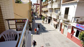 Vista de una calle con edificios, balcones y un cartel que dice 'El Puente'.