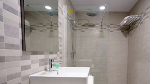 A modern bathroom with a white sink, a glass shower enclosure, and a towel rack on the wall. - Hostal Anna Benidorm (Benidorm)
