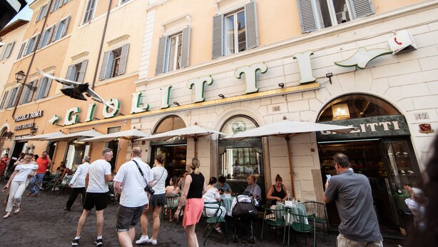 A street scene with outdoor seating at a cafe named "GIOLETTO." -  BEIGE ET BLE' ' Guesthouse (Rome)