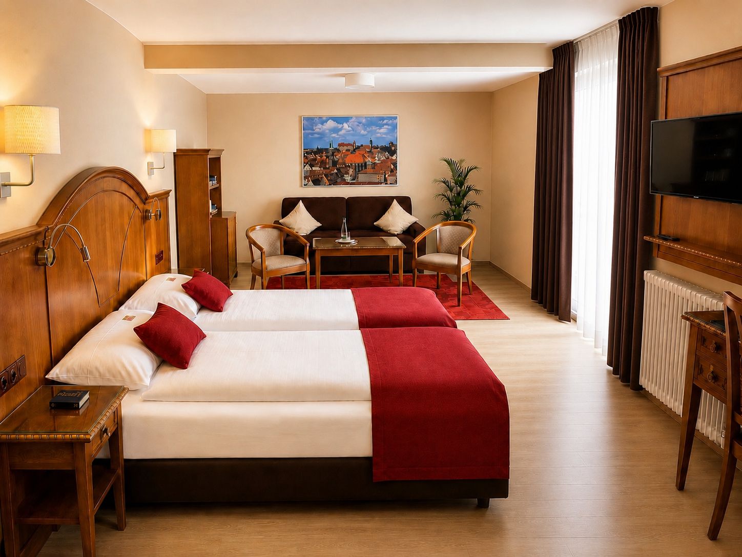 Habitación de hotel con cama doble, dos sillones, una mesita y un televisor. En la pared, un cuadro.
