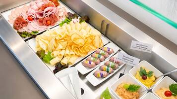 Ein Buffet mit verschiedenen Speisen, darunter Fleisch, Pasta und Dips.