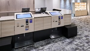 A hotel reception desk with two computer monitors, a cash register, and a small display screen. - Hotel Villa Fontaine Tokyo - Nihombashi Mitsukoshimae (Tokyo)