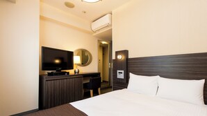 A hotel room with a bed, a desk, a television, a mirror, and an air conditioning unit. - Hotel Villa Fontaine Tokyo - Nihombashi Mitsukoshimae (Tokyo)