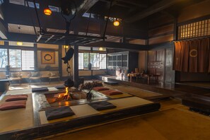 A traditional Japanese-style room with tatami mats, a low wooden table, and a fireplace. - Wanosato (Takayama)