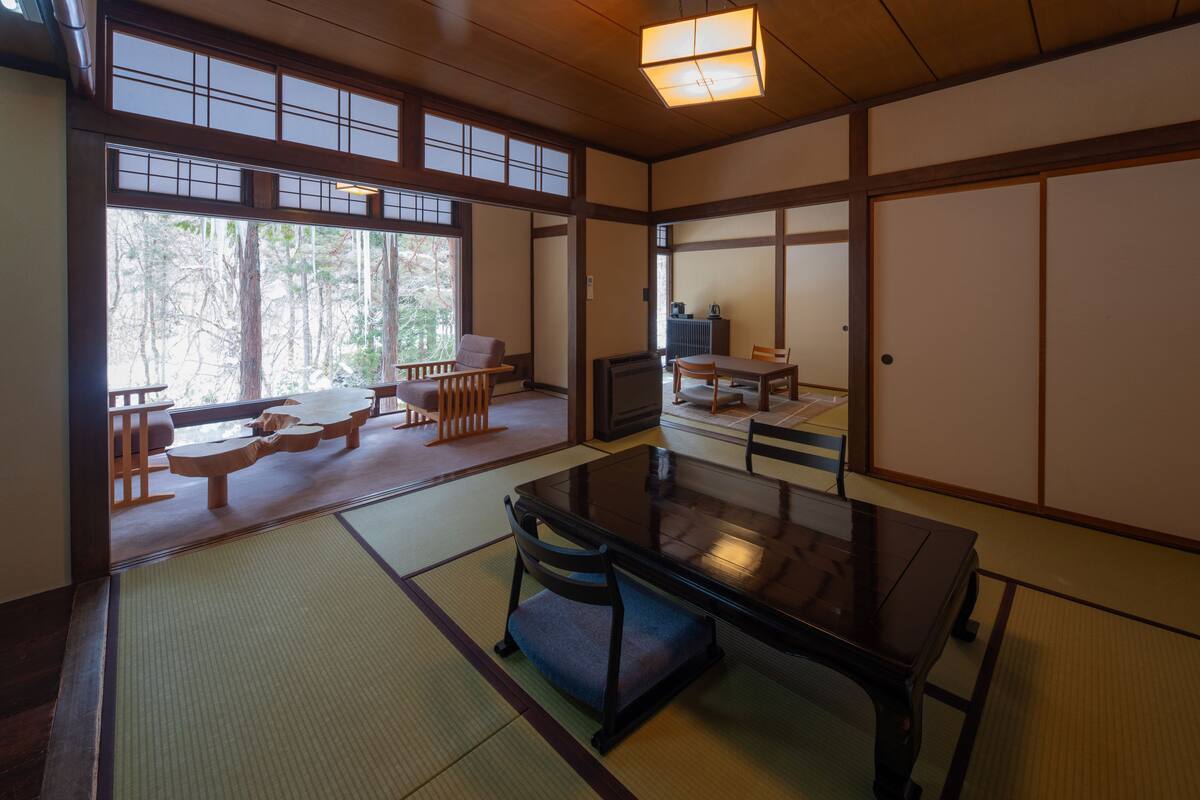 A traditional Japanese-style room with tatami flooring, a low table, and sliding doors.