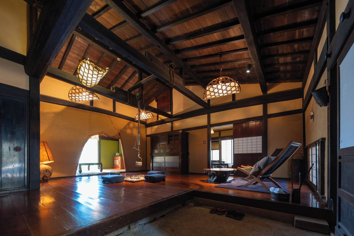A spacious room with a wooden ceiling, a large window, and a traditional Japanese sliding door.