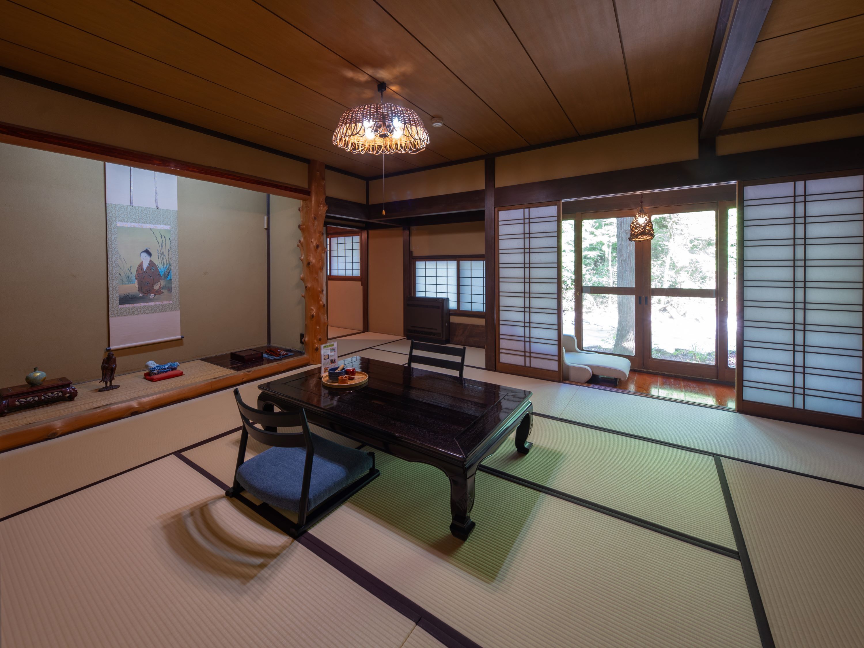 A traditional Japanese room with tatami flooring, a low table, and sliding doors.