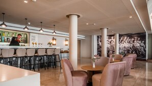 Un'area bar moderna con un barista, un bancone e una disposizione dei posti a sedere.