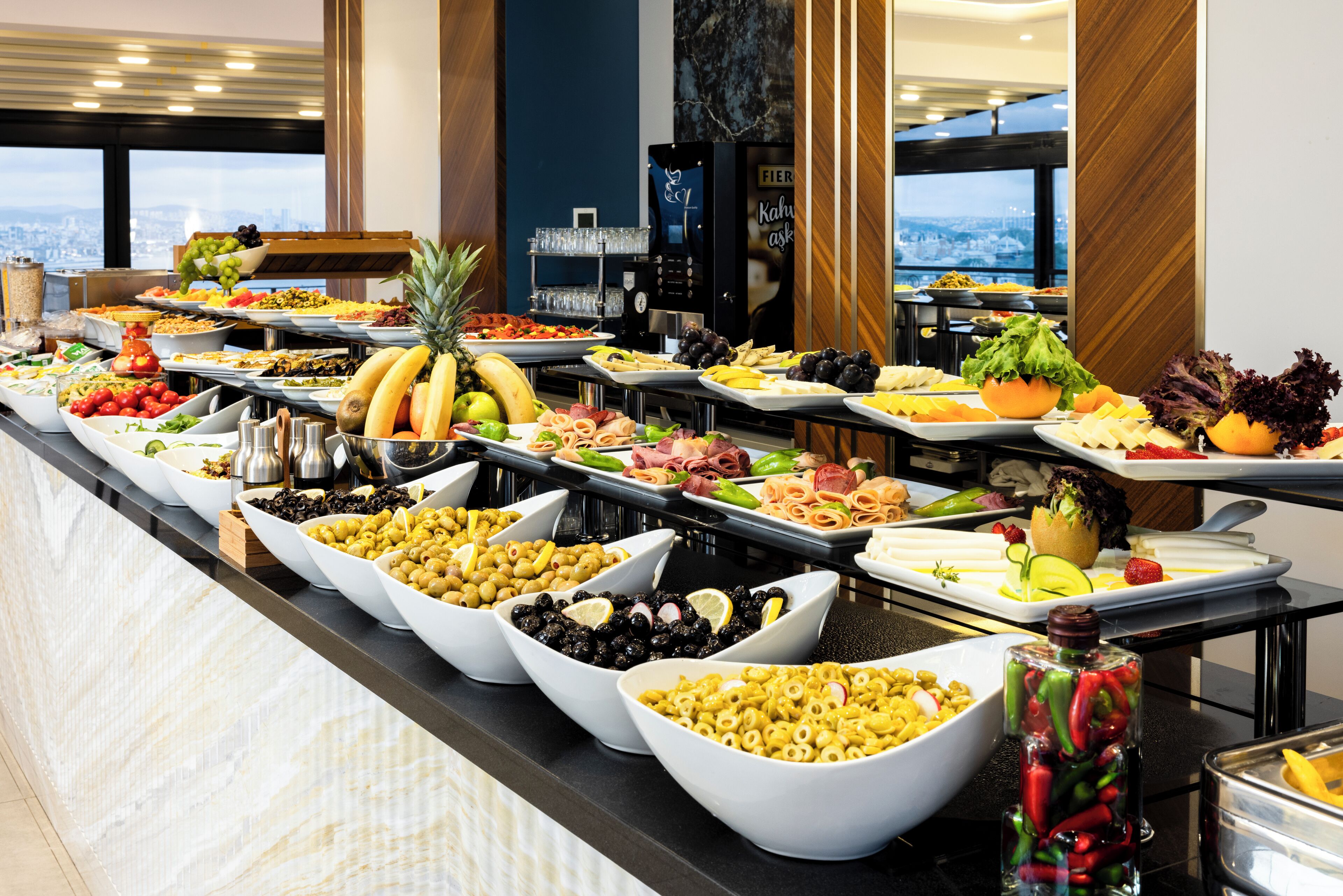 Un buffet proposant une variété de plats, notamment des fruits, des fromages et des salades.