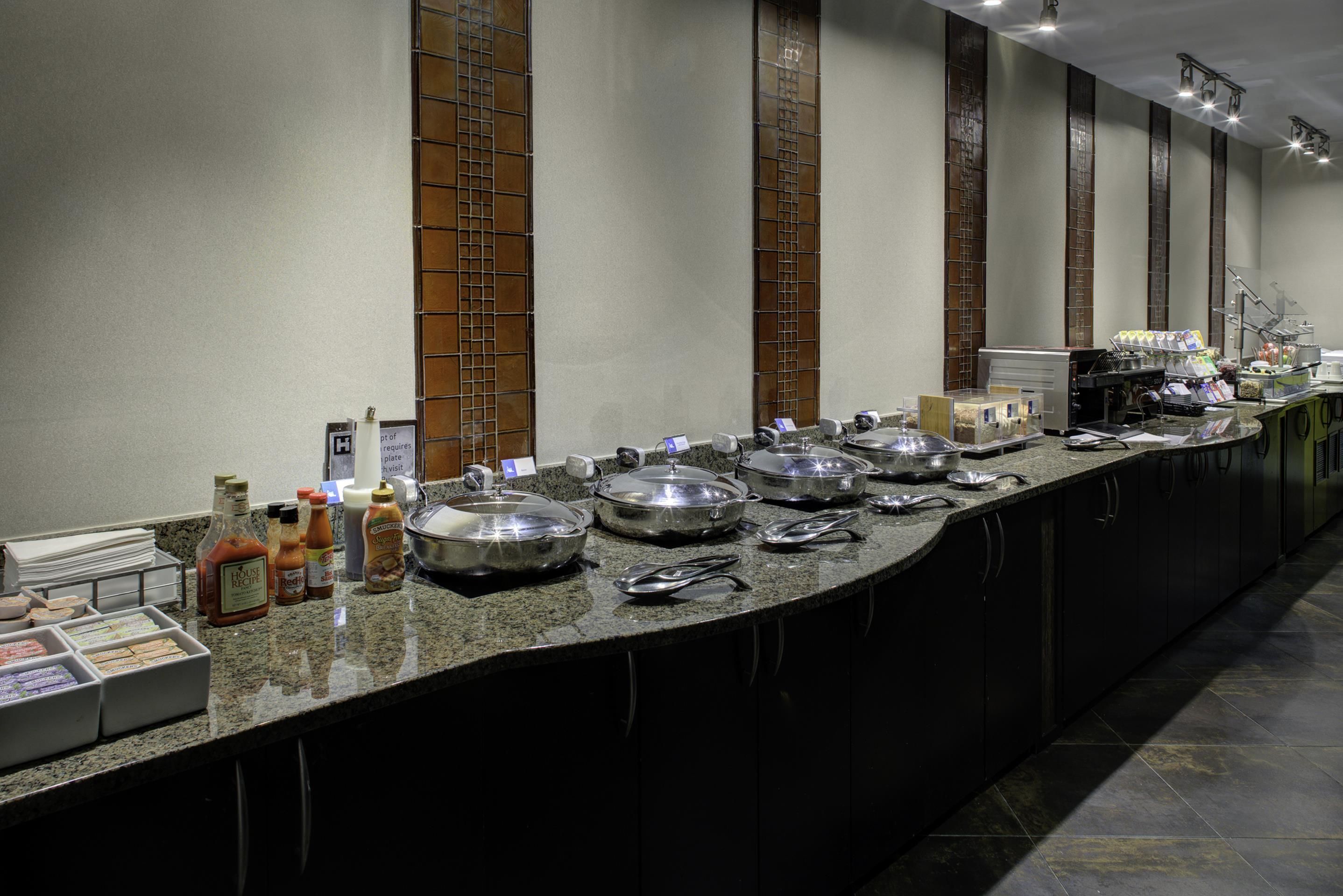 A buffet setup with various food containers and condiments.