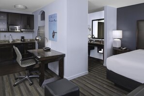 Une chambre d’hôtel équipée d’un bureau, d’une chaise et d’un lit.