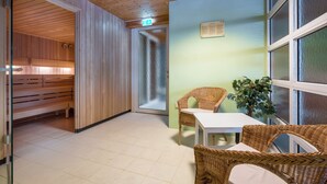 Een houten interieur met een bank, een tafel en rieten stoelen.
