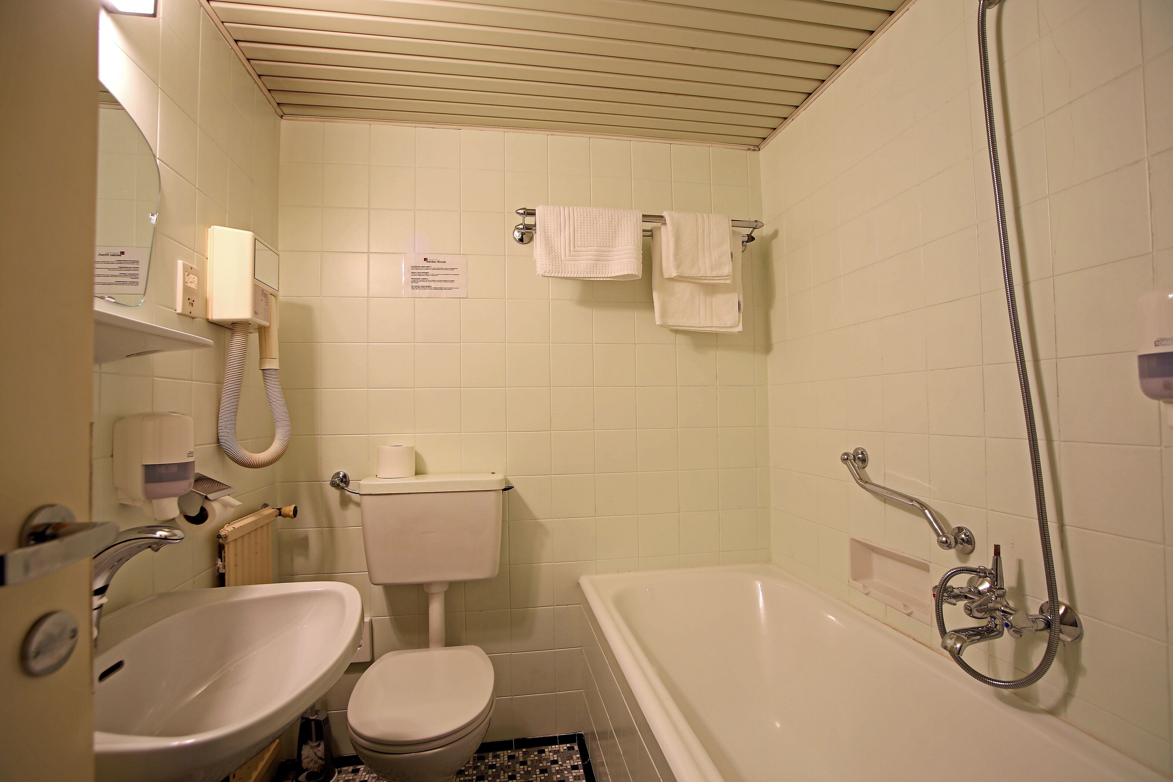 Un baño con lavamanos, inodoro y bañera.