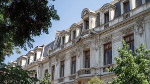 A historic building with ornate architectural details, including arched windows and decorative moldings. - Happy House Hostel (Santiago)