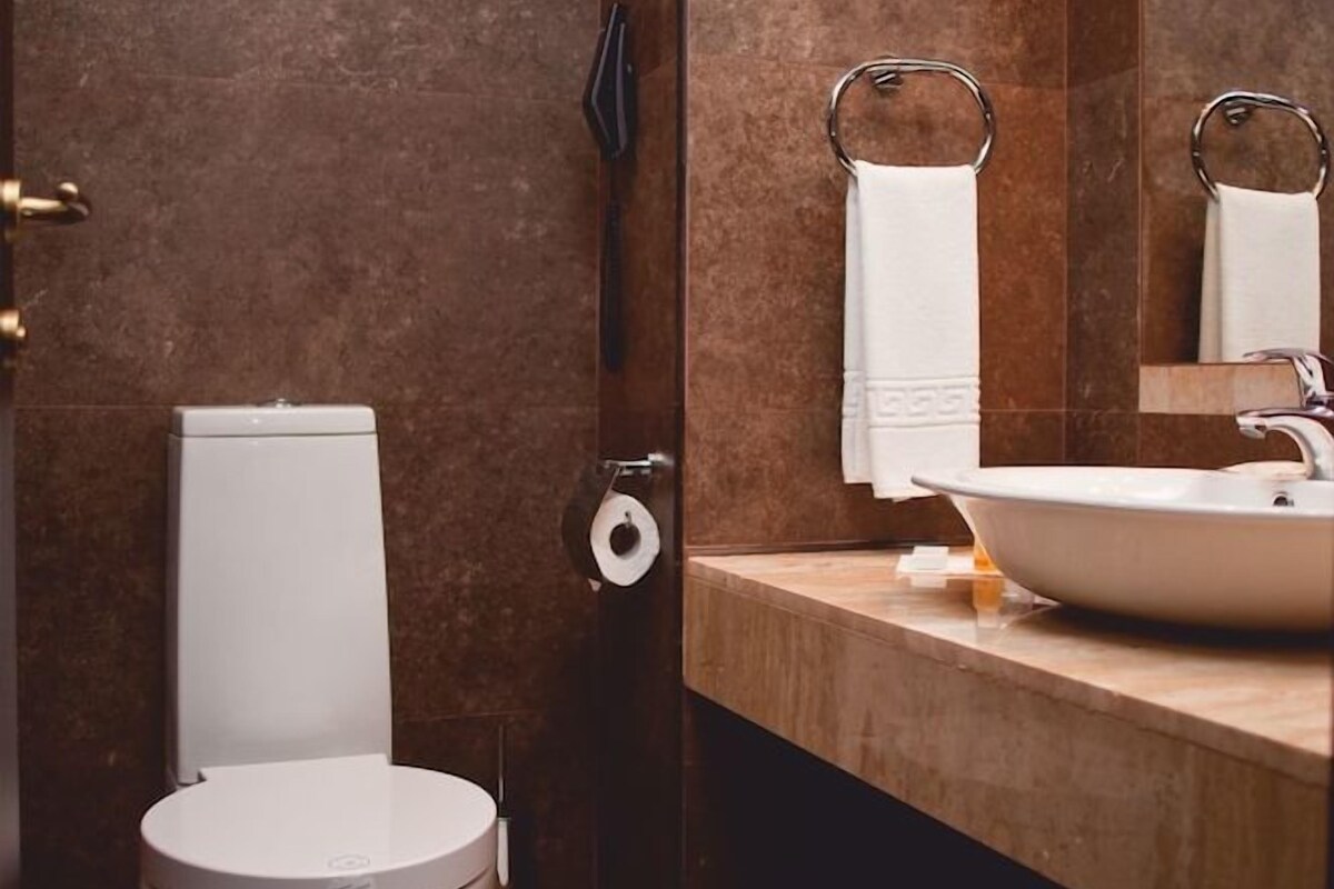 Une salle de bain moderne avec des toilettes, un lavabo et un miroir.