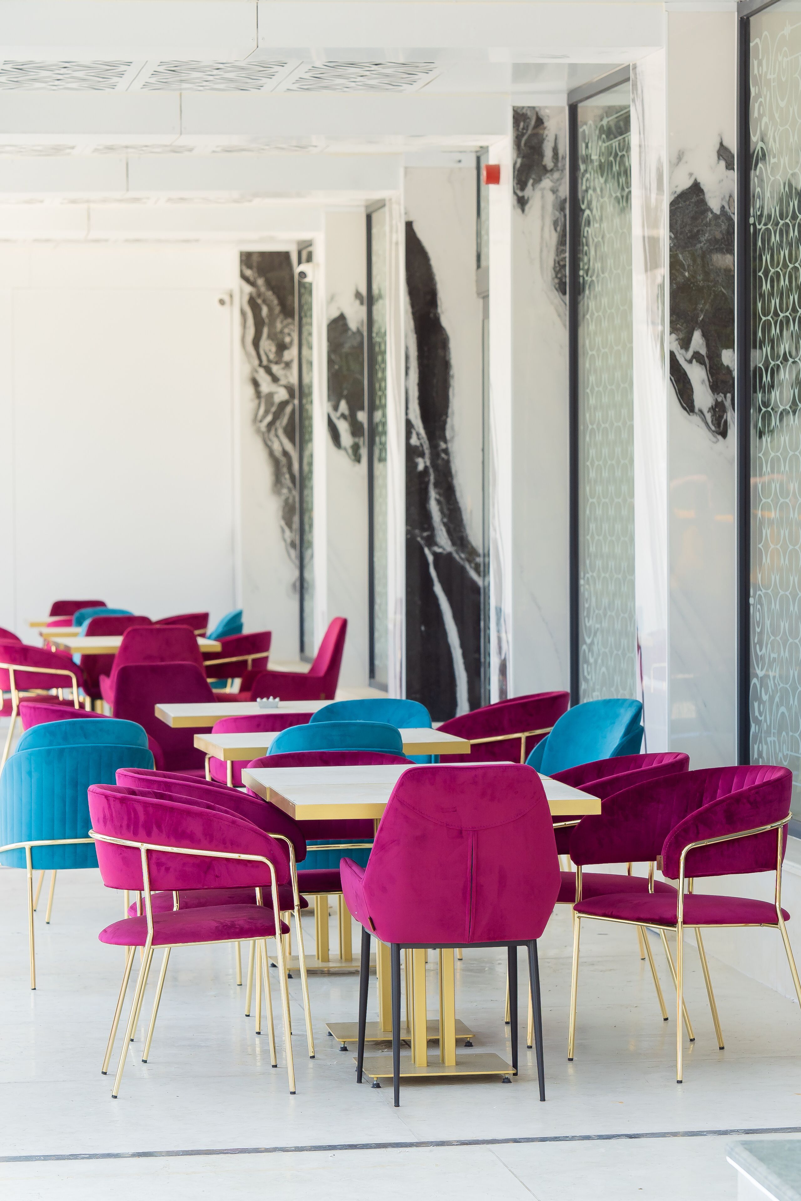 A dining area with tables and chairs, featuring a modern design with a mix of colors.