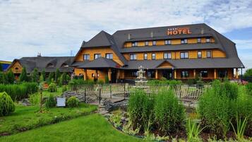 A hotel with a traditional architectural style, featuring multiple levels and a prominent sign.