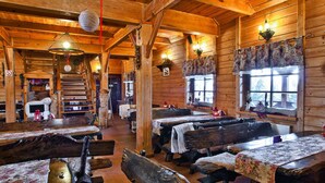 A rustic wooden interior with benches, tables, and a staircase. - Hotel Czardasz Spa & Wellness (Plock)