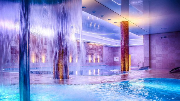 An indoor swimming pool with multiple water jets and a modern, well-lit interior. - Hotel Czardasz Spa & Wellness (Plock)