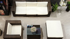 A modern living room with a large sofa, two side tables, and a coffee table. - Hotel Czardasz Spa & Wellness (Plock)