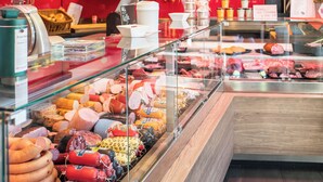 A deli counter with various meats and cheeses displayed in a glass case. - Königsteiner Hof (Königstein)