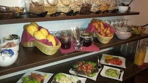 A buffet with various food items including bread, salads, and condiments. - Art Inn Hotel Dinslaken (Dinslaken)