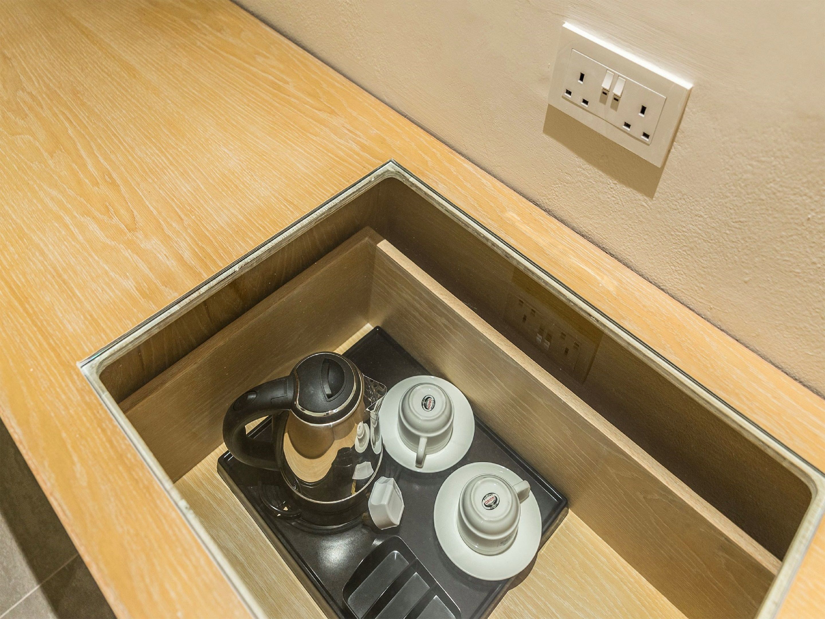 Cocina compacta con cafetera, hervidor y microondas integrados.