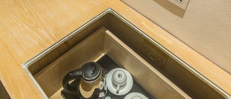Cocina compacta con cafetera, hervidor y microondas integrados.