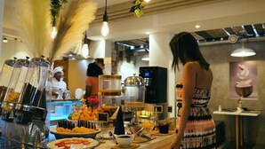 A buffet area with various food items and a coffee station.