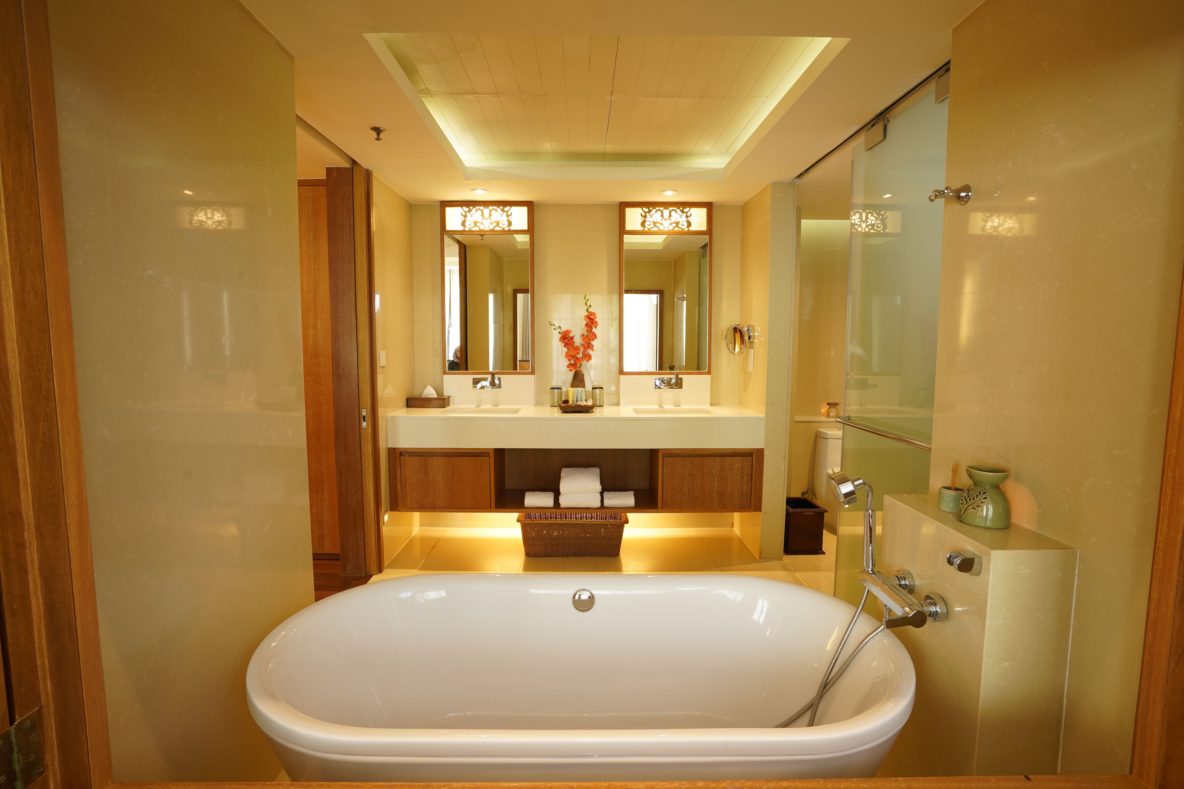 A modern bathroom with a large bathtub, a vanity with a mirror, and a glass shower enclosure.