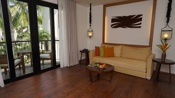 A living room with a sofa, coffee table, and a view of a balcony with outdoor furniture.