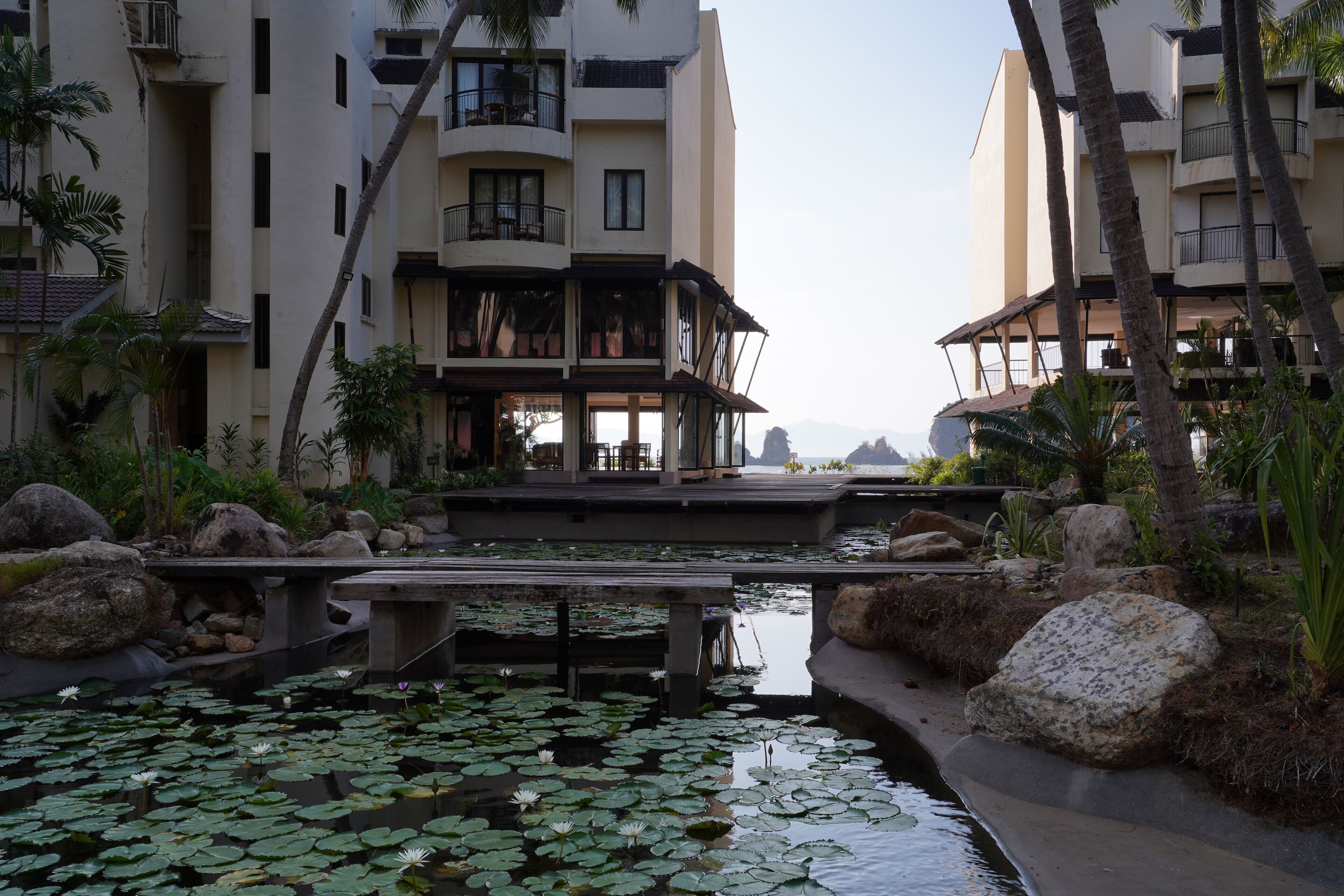 Un hôtel doté d’un jardin aquatique, de palmiers et offrant une vue sur l’océan.