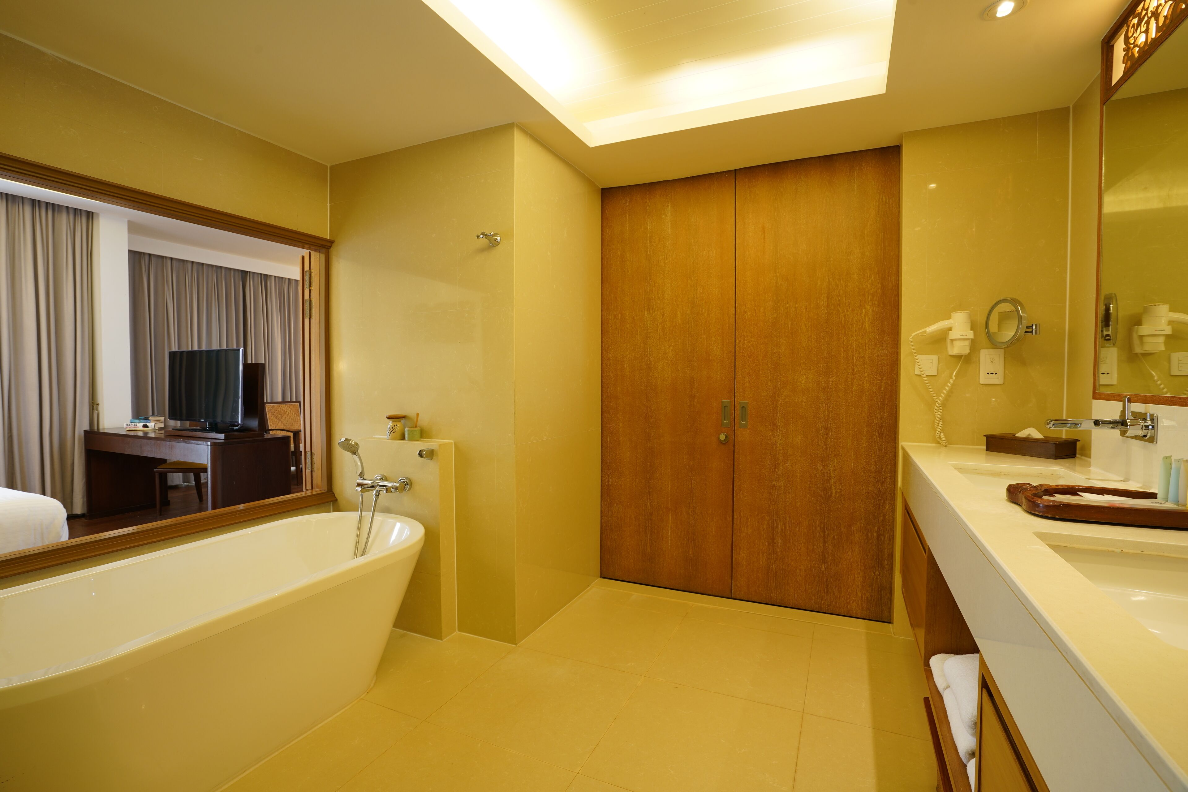 A modern bathroom with a bathtub, vanity, and a large mirror.